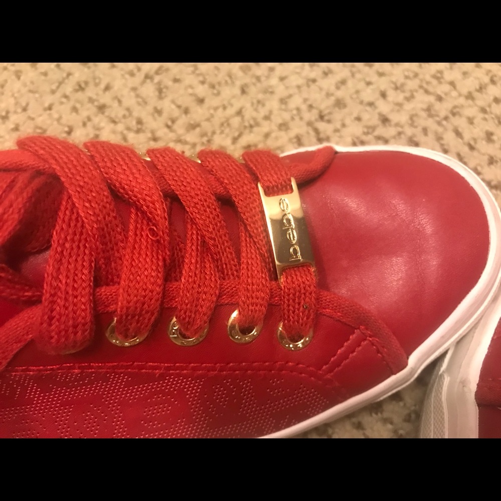 Red sneakers with gold accent.